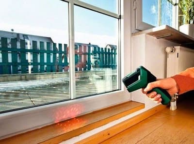 Photo d'une personne qui contrôle la qualité des murs avec un appareil