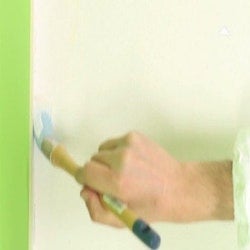 Une personne qui peint les angles avec une brosse à rechampir