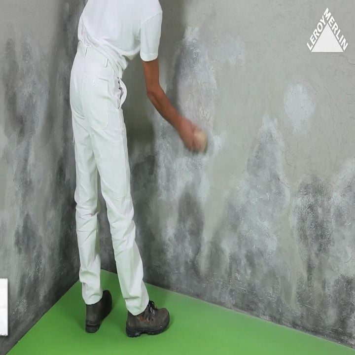 photo d'un homme frottant énergiquement le mur