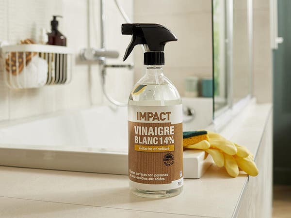 un spray nettoyant de vinaigre blanc avec une étiquette marron dans une salle de bains