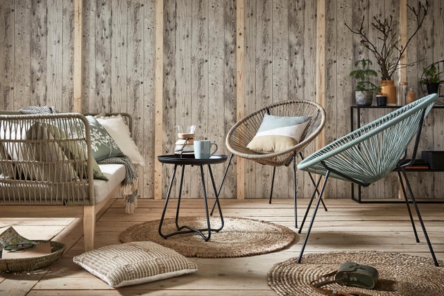 Photo Leroy Merlin de mobilier de jardin devant un mur en bois. 