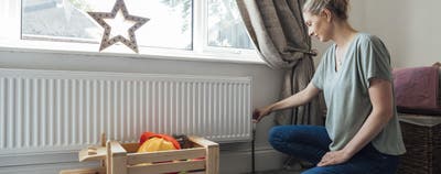 Photo d'une femme devant son radiateur
