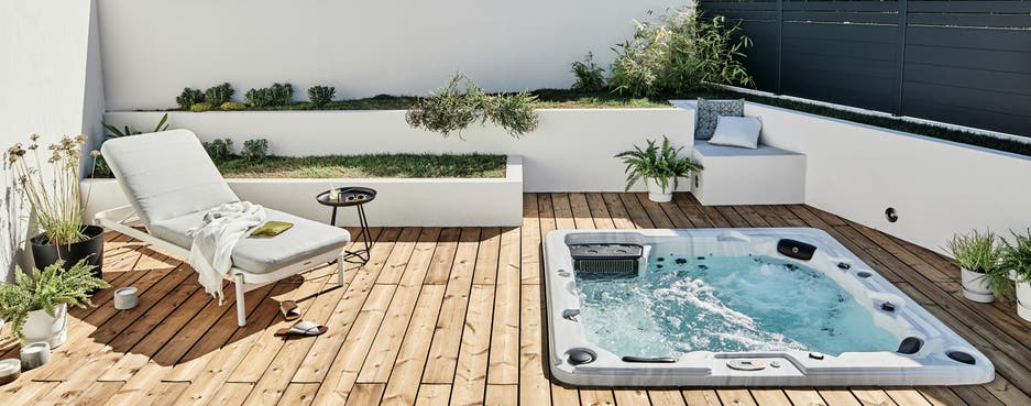 photo d'une terrasse en pin avec un transat et un spa