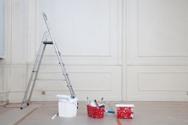Photo d'un mur blanc avec des moulures prêt à être repeint en blanc. 