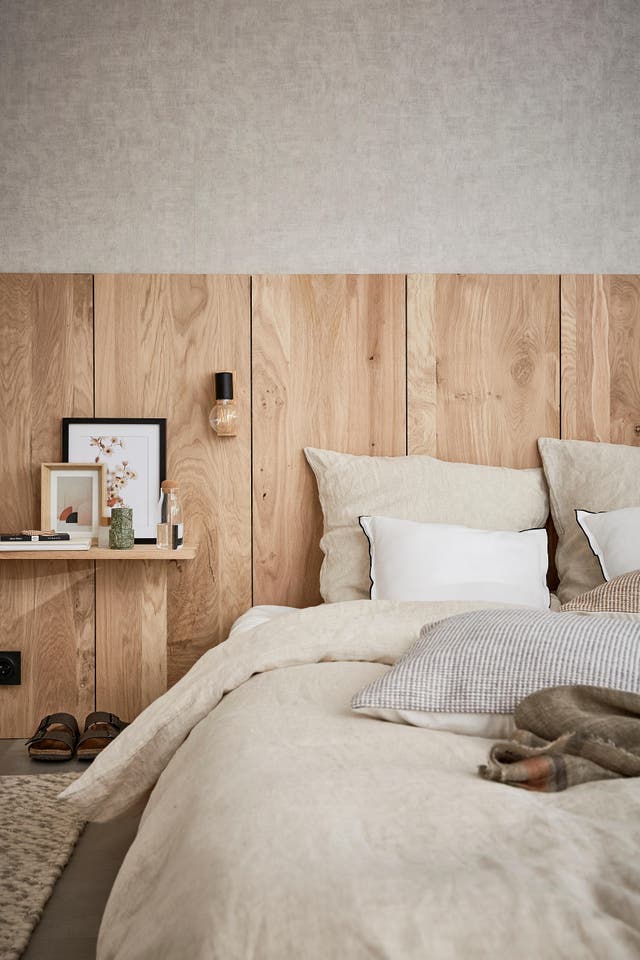 Photo d'un lit avec une tête de lit en bois. 