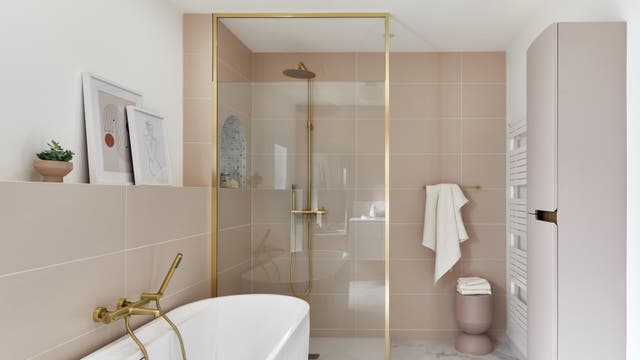 photo d'une salle de bains dans les tons beige et blanc avec une robinetterie doré