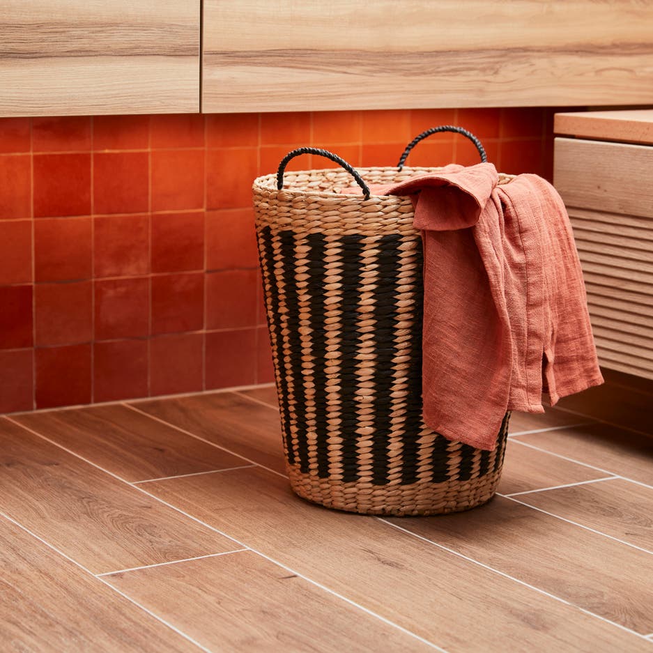 Photo Leroy Merlin d'un panier à linge en matière naturel beige et noir. 