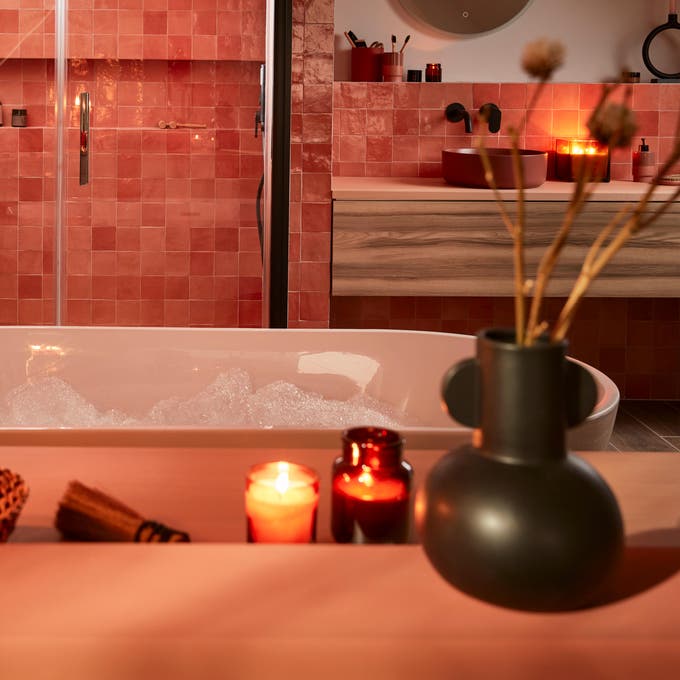 Photo Leroy Merlin d'une baignoire dans une suite parentale ambiance cosy avec des bougies allumées. 