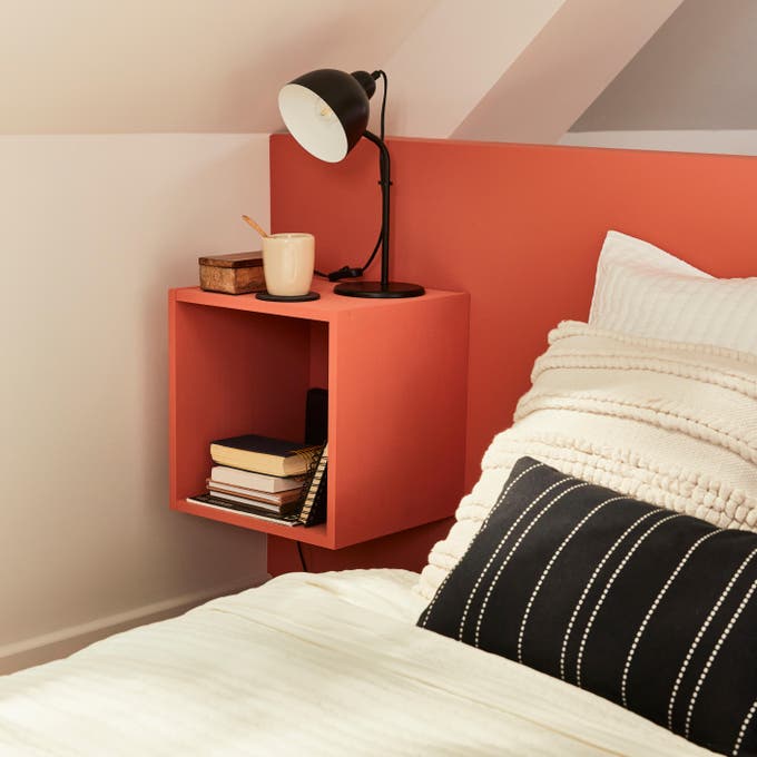 Photo Leroy Merlin d'une tête de lit avec caisson de rangement couleur orange. 