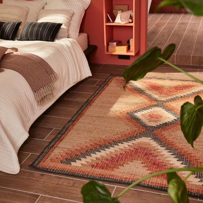 Photo Leroy Merlin d'un tapis à motif dans une suite parentale chaleureuse et colorée. 