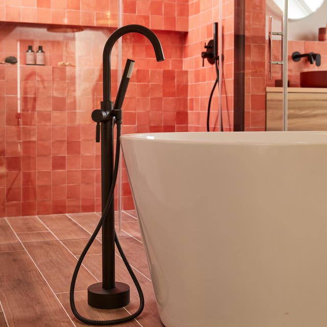 Photo Leroy Merlin d'une robinetterie noire sur pied à côté d'une baignoire îlot. 