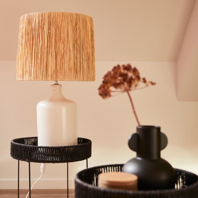 Photo Leroy Merlin d'une lampe à poser sur une petite table noir en matières naturelles. 