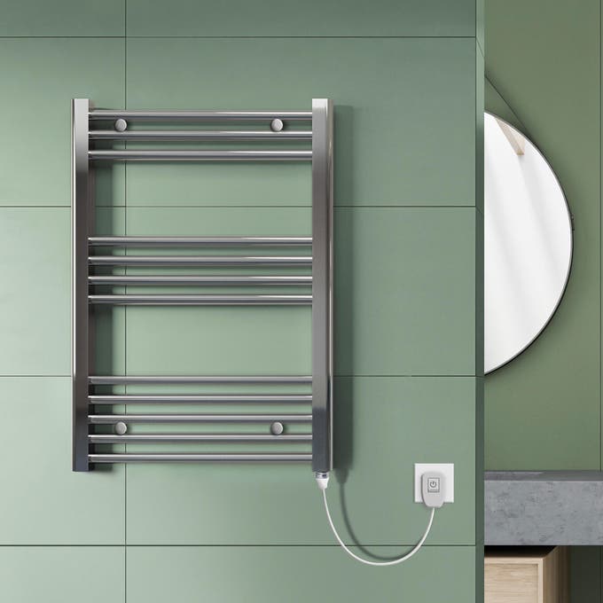 Toalheiro elétrico de casa de banho metalizado numa parede com azulejo verde e regulador de temperatura.
