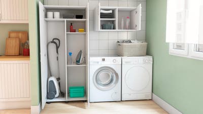 Un lavadero con lavadora y secadora de estantería