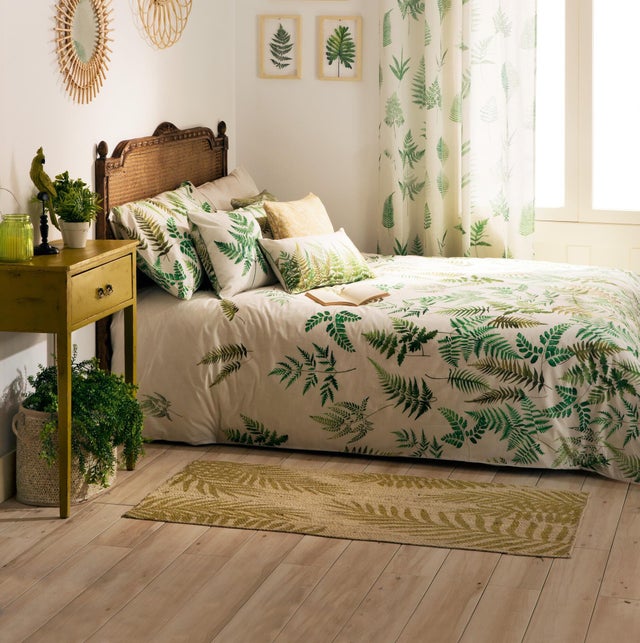 Dormitorio con ropa de cama con motivos botánicos.  