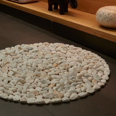 Viste el suelo del baño con una alfombrilla de piedras