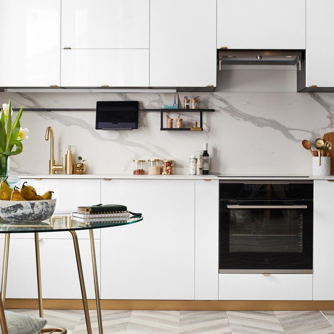 Cocina moderna en blanco con el salpicadero en acabado mármol. 