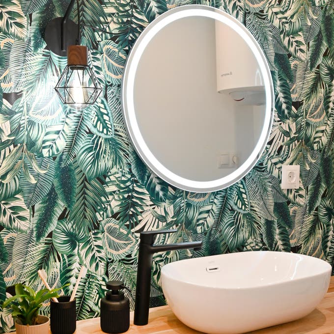 Baño con papel pintado con motivos vegetales. 