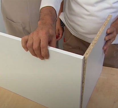 senhor a verificar se as placas de melamina estão com o tamanho correto 