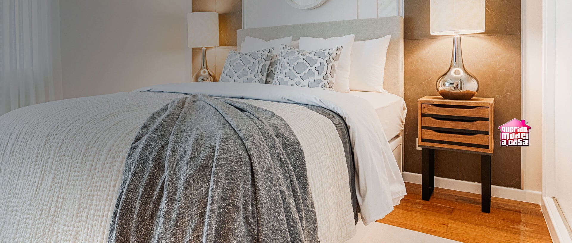 Quarto com cama de casal e duas mesas de cabeceira, um candeeiro de teto, espelho, candeeiros de mesa, cortinados brancos e tapete