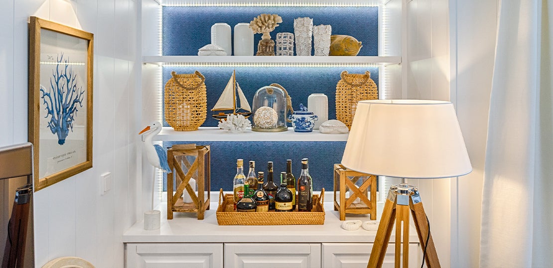 Sala com móvel antigo recuperado, pintado de branco e fundo forrado com papel de parede