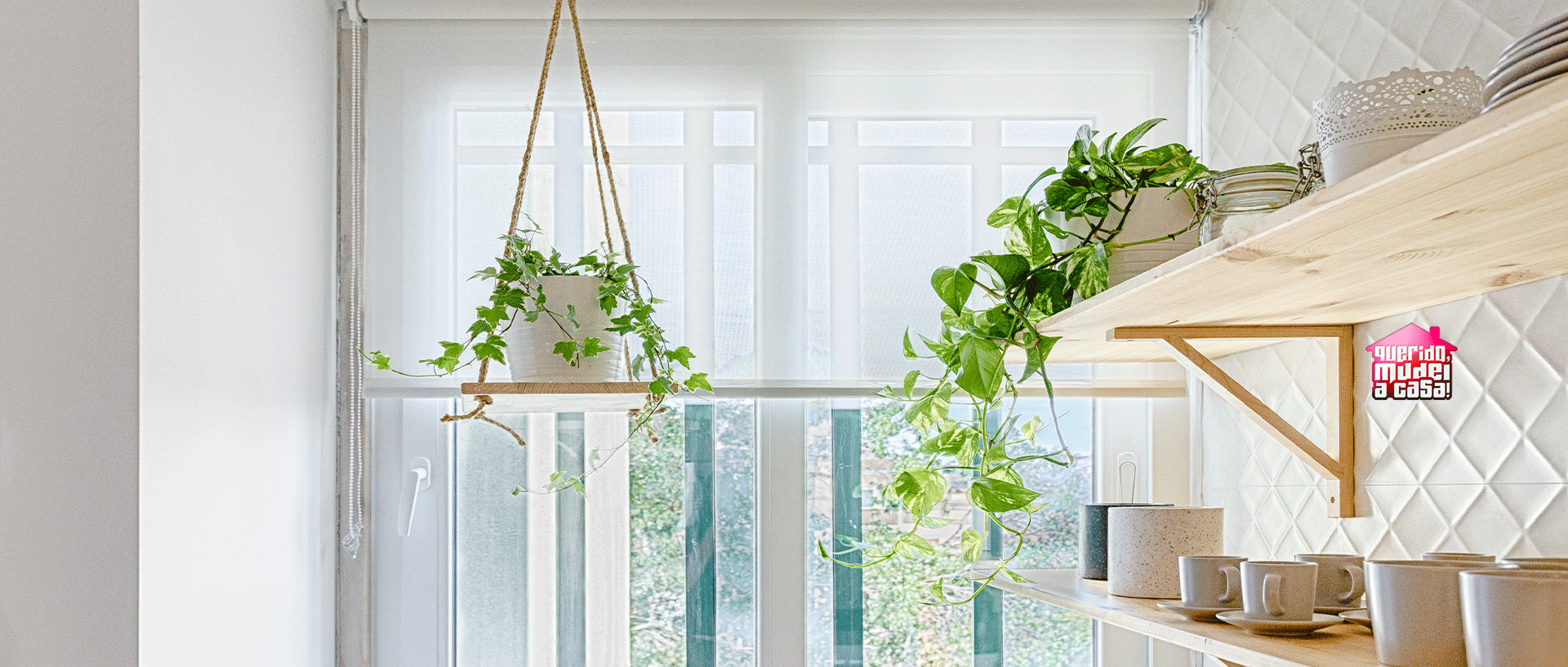 Suporte de plantas pendurado no teto com uma janela de fundo com estores e ao lado prateleiras de madeira