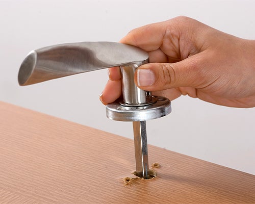 Senhora a retirar a fechadura da porta.