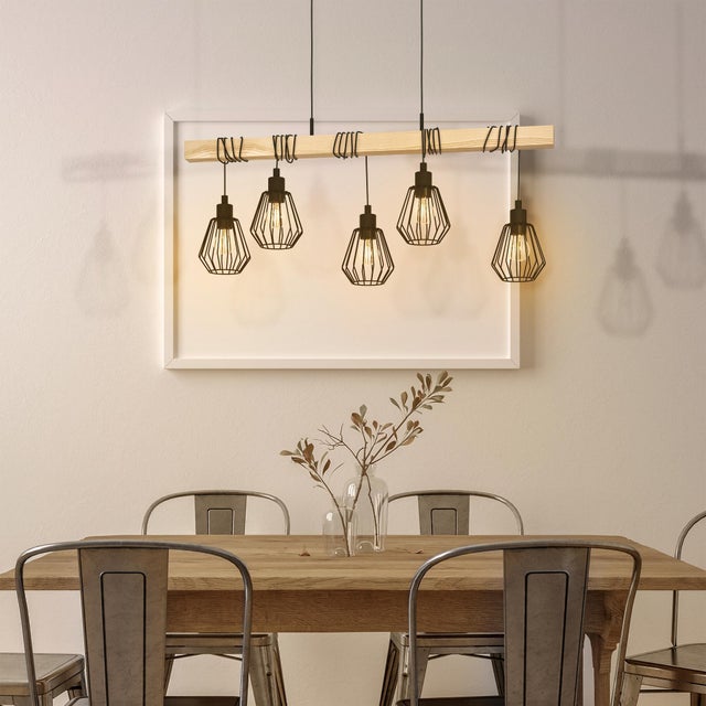 Comedor con lámpara industrial con listón de madera y elementos geométricos.  