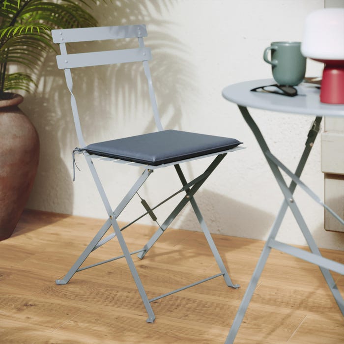uma cadeira de jardim em aço azul com uma mesa, material floral