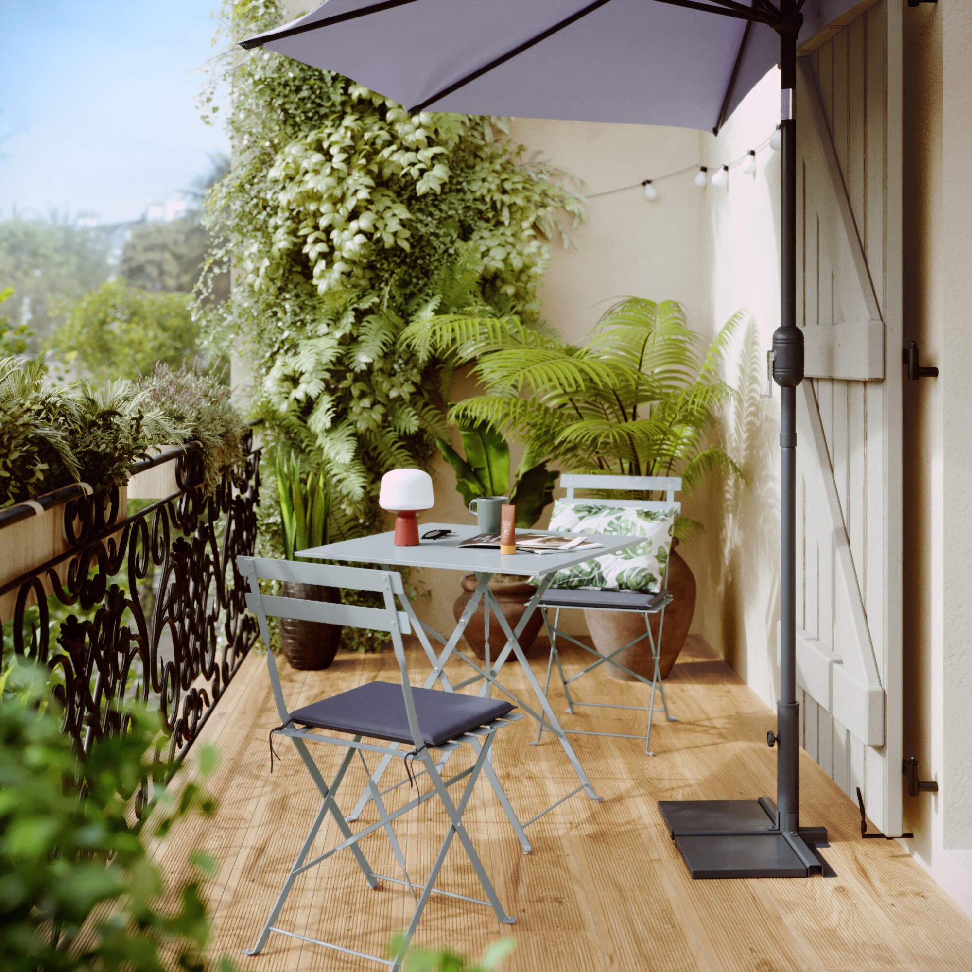 cenário de jardim com mesa quadrada e duas cadeiras azuis, além de guarda-chuva e material vegetal - 1