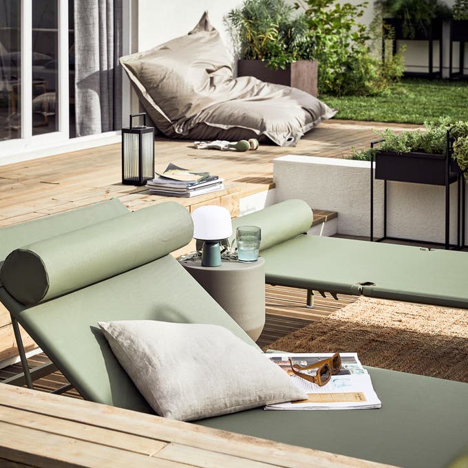 photo de bains de soleil et d'un grand pouf dans le jardin sur la terrasse en bois