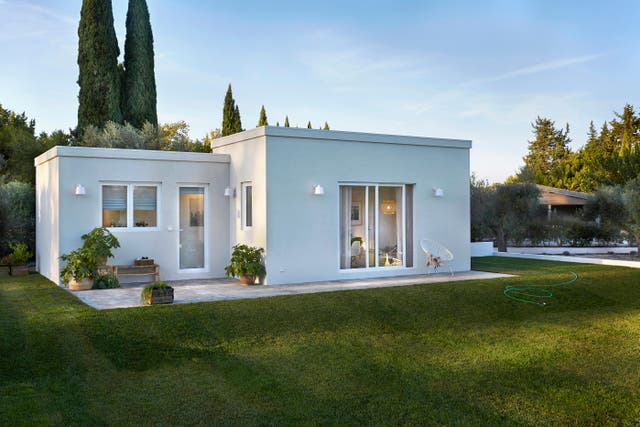 photo d'une maison blanche moderne avec une petite terrasse et un grand jardin