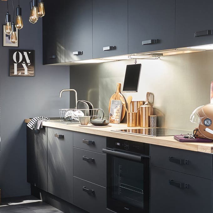 Cocina moderna de color negro con encimera de madera. 