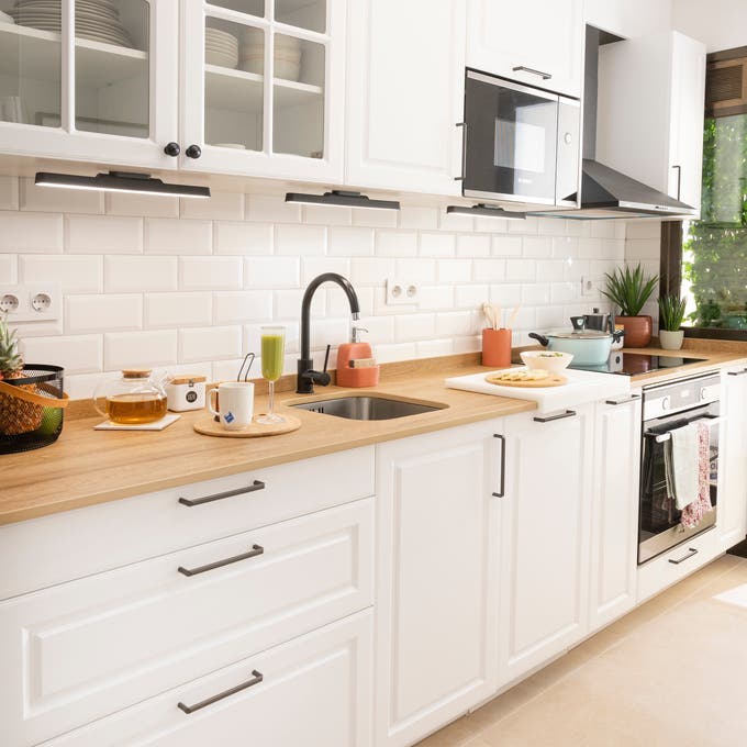 Cocina moderna blanca con encimera de madera. 