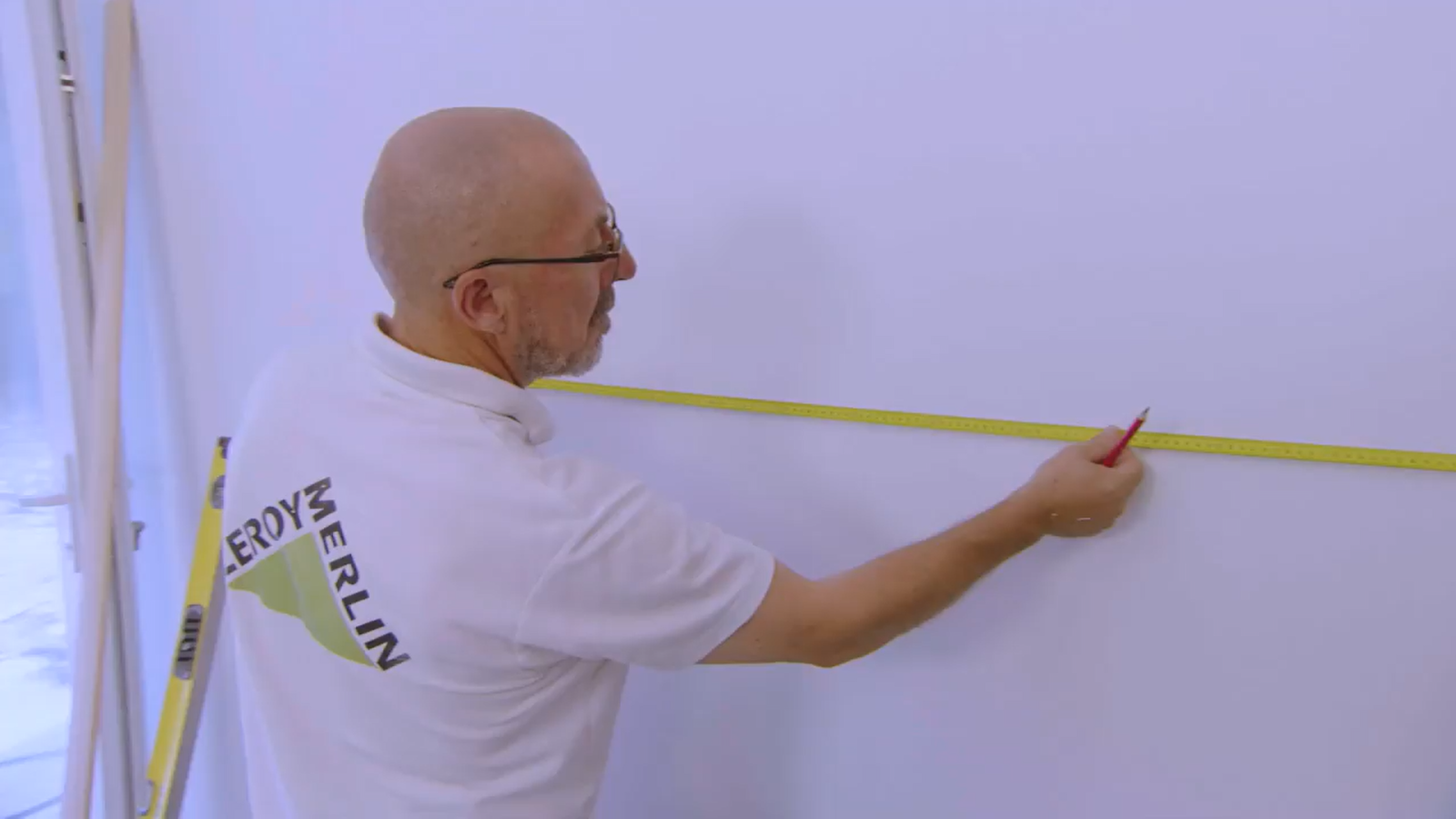 pessoa com uma fita métrica a marcar as medidas do quadro