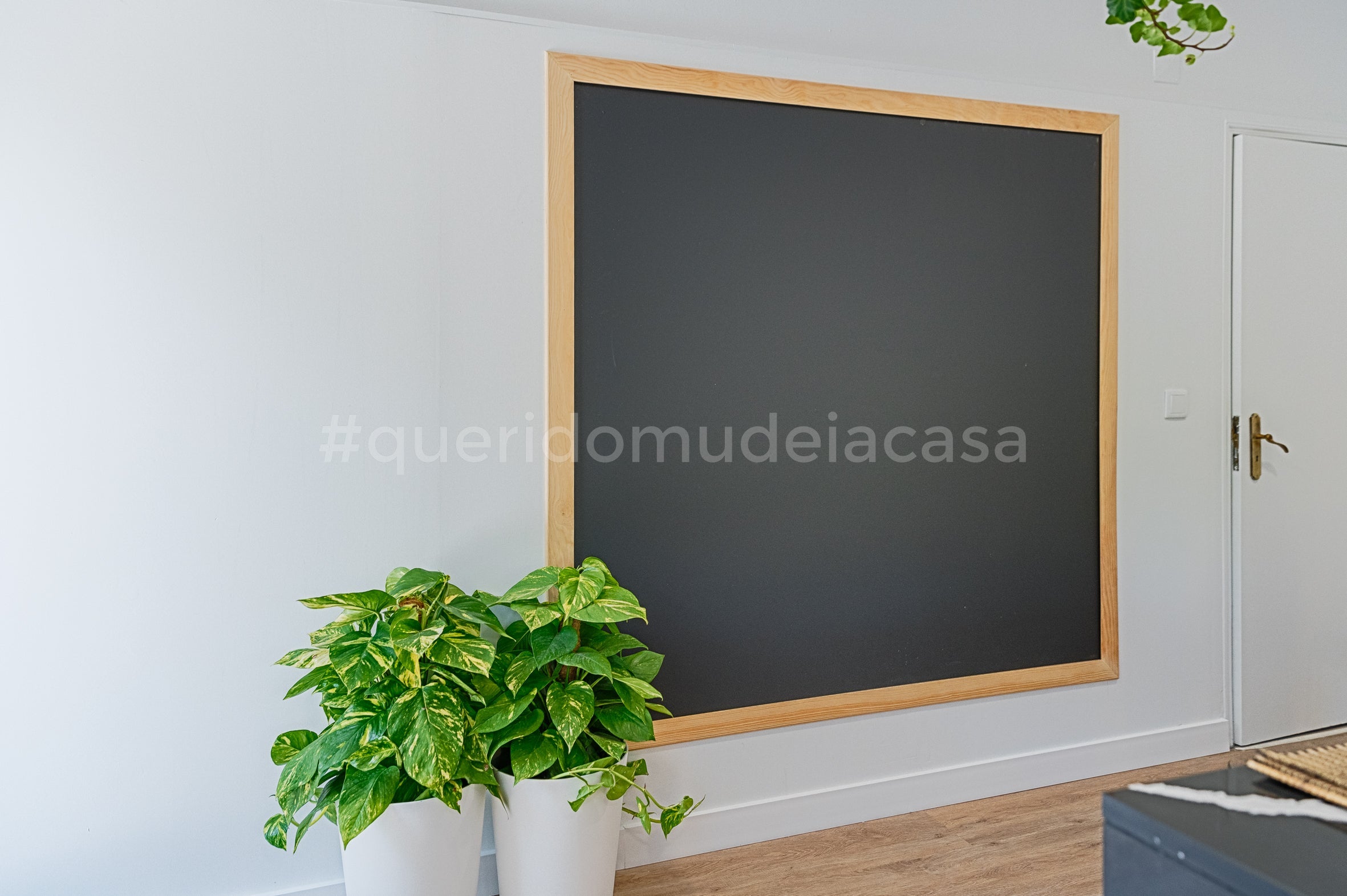 um quadro de ardósia grande com moldura em madeira junto à porta da cozinha