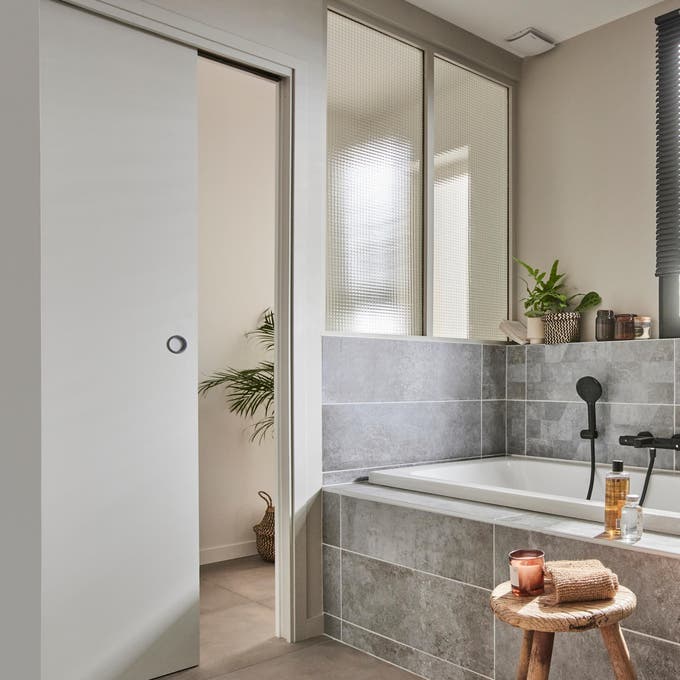 photo d'une salle de bains avec porte à galandage pour un gain de place garantis