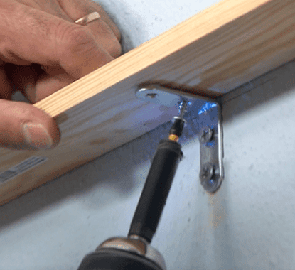 Pregar uma prateleira numa parede com um esquadro, parafusos e uma aparafusadora