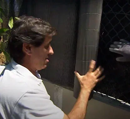 Senhor a desenrolar o rolo da vedação de vime no local onde a vai aplicar
