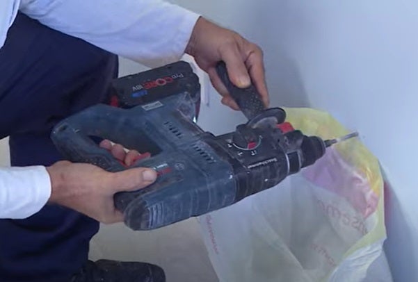 fazer furos numa parede com aparafusadora e ajuda de um saco para a sujidade