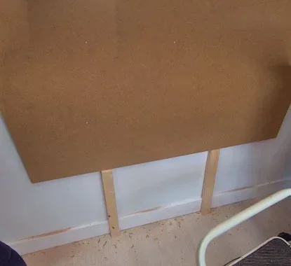painel junto a uma parede com ajuda de dois apoios