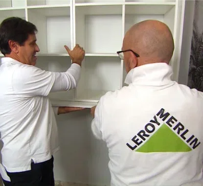dois senhores a colocarem as duas estantes de cubos na estrutura da cama