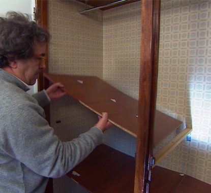 senhor a retirar prateleira de madeira de um roupeiro