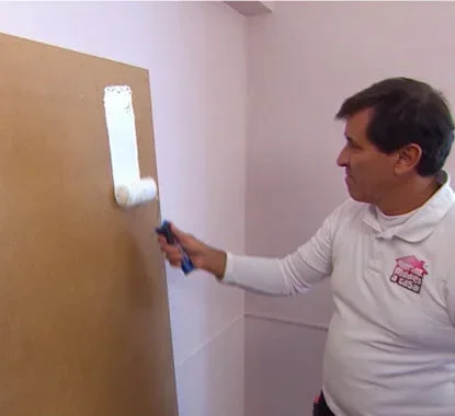 Senhor a pintar a placa de branco