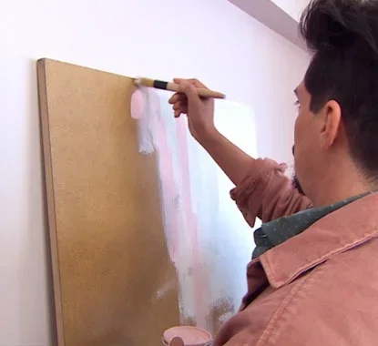 Senhor a pintar com um pincel a placa com várias cores