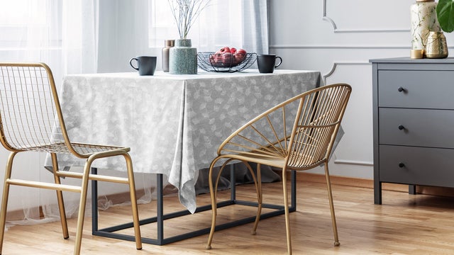 Mesa de comedor vestida con mantel de estampado vegetal