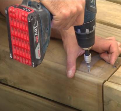 Pessoa a encaixar as várias placas de deck e a aparafusar 