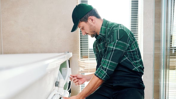 grafika - montażysta instaluje wannę