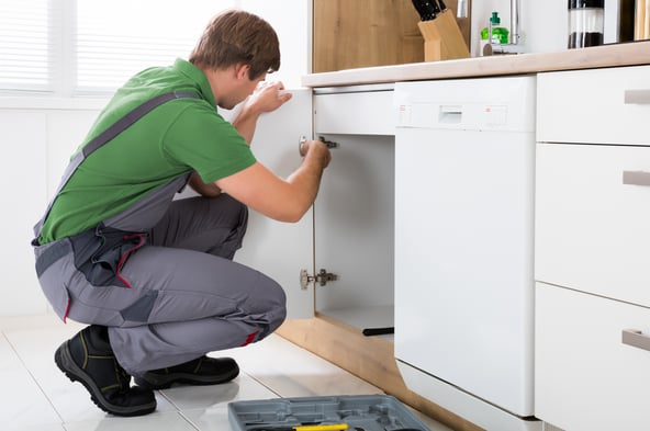 Zdjęcie przedstawiające mężczyznę montującego kuchnię
