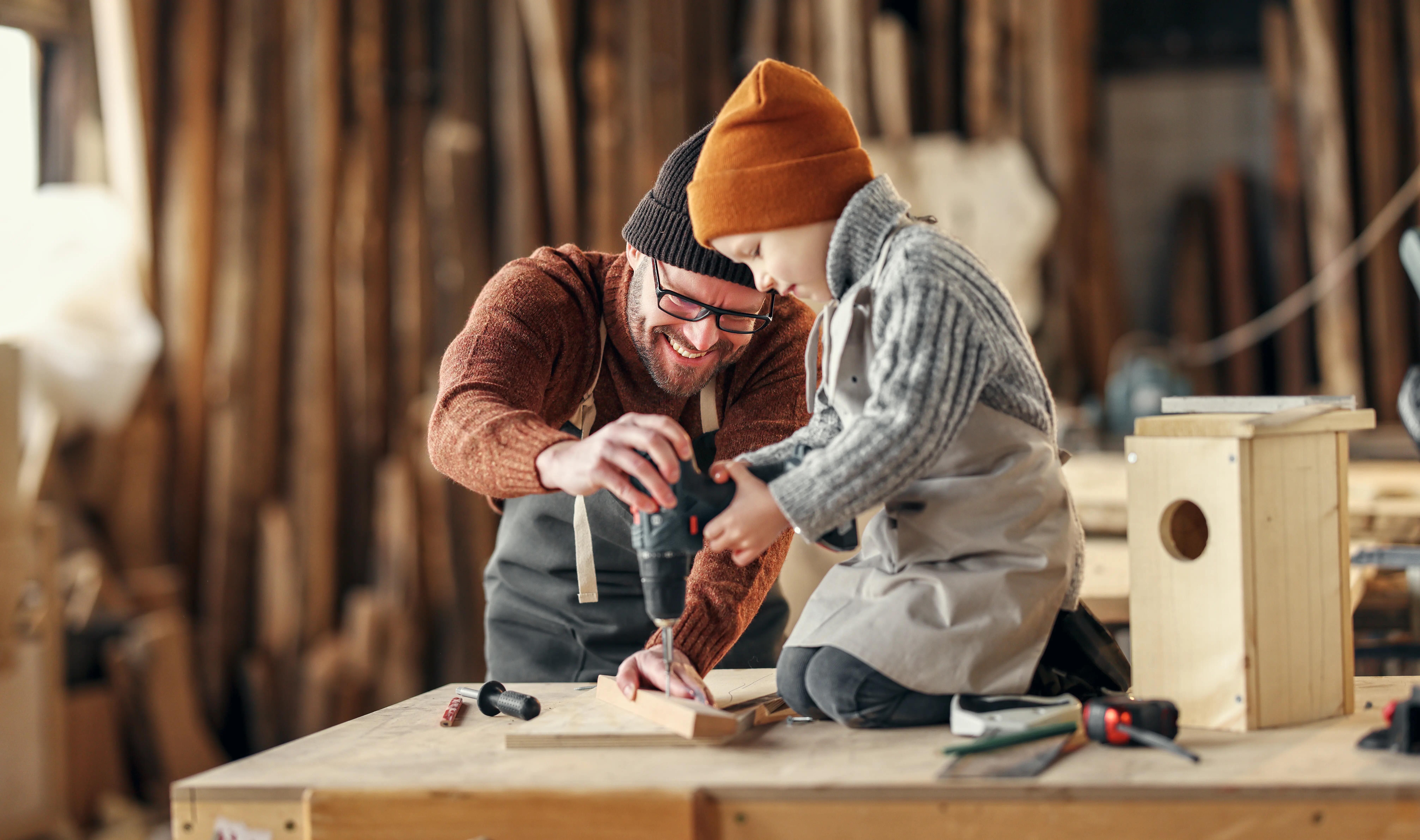 pai e filho a usar um berbequim para fazer um DIY em madeira